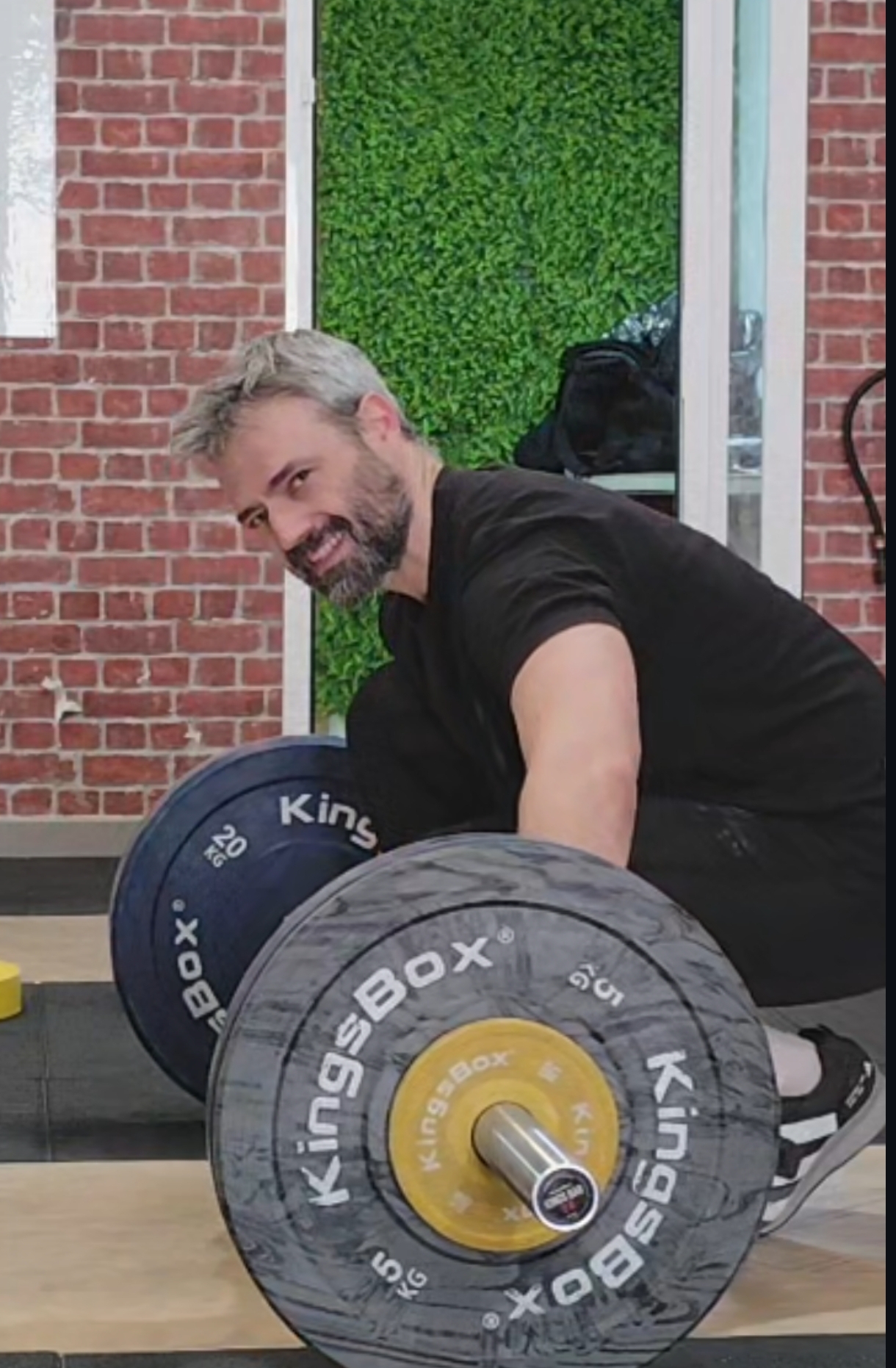 Javi García sonriendo junto a los discos de una barra